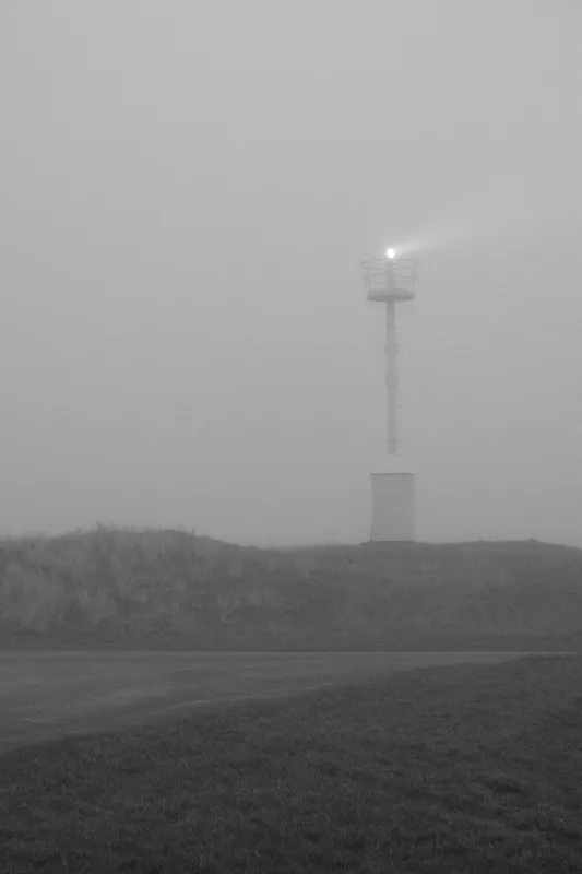 Guiding light on a foggy day on the dutch northsea coast